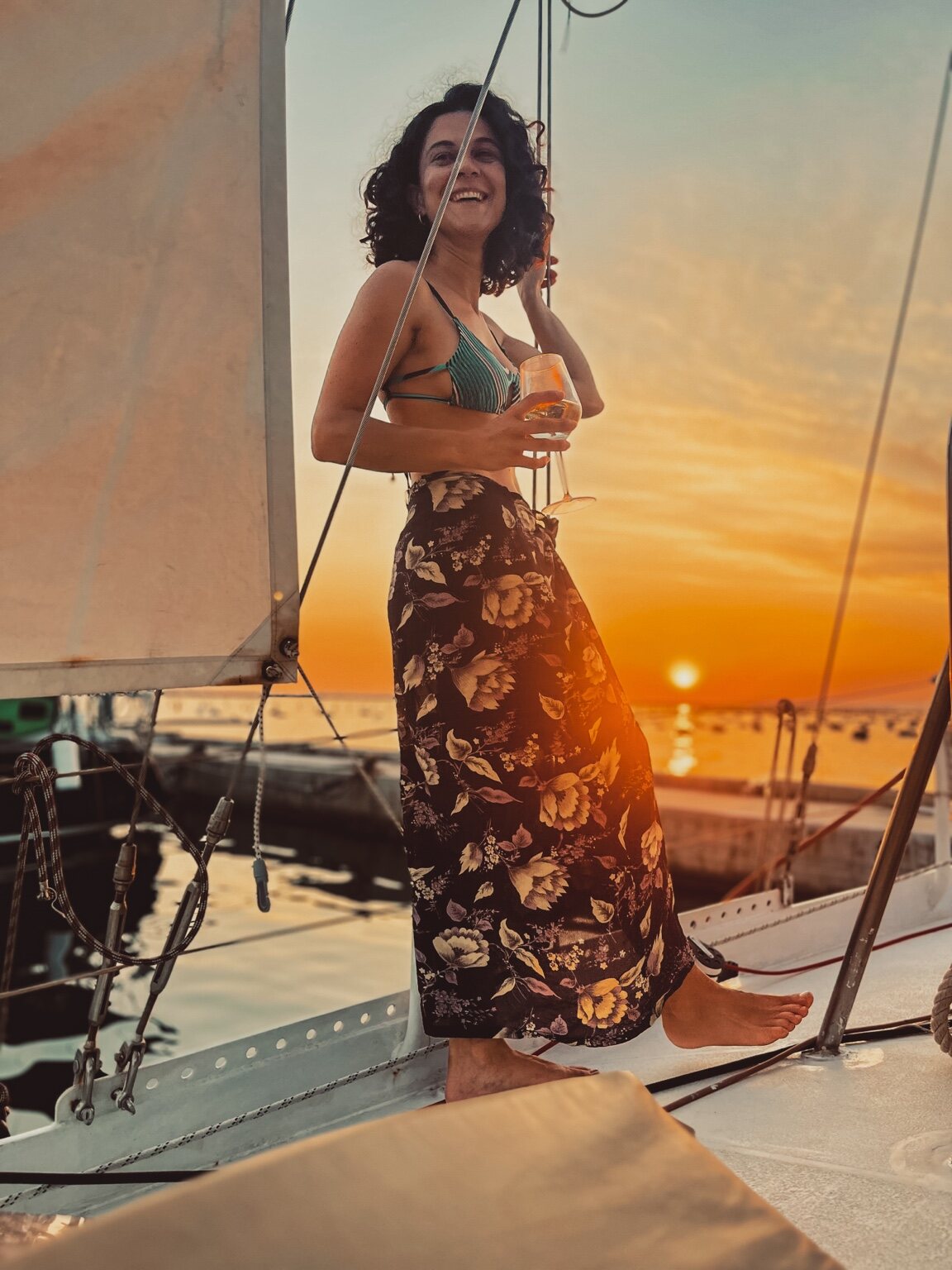 Federica sorride a bordo con un bicchiere al tramonto