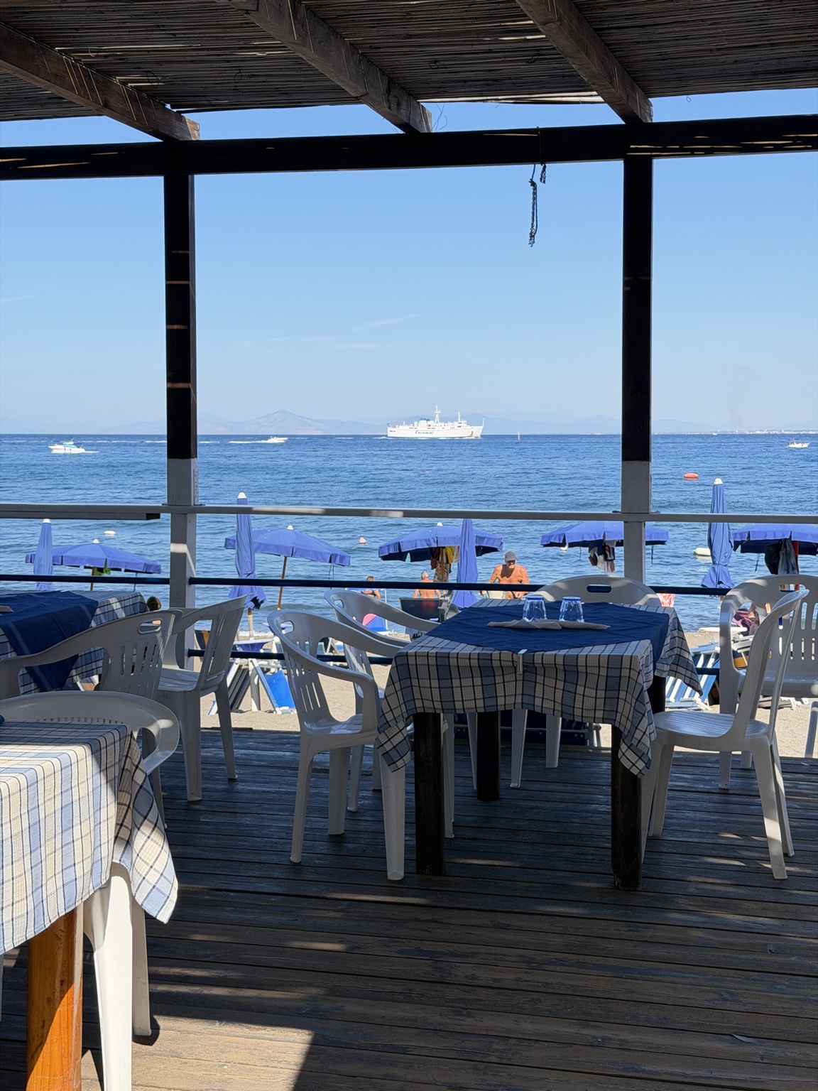 Tavoli apparecchiati sulla terrazza di un ristorante in spiaggia